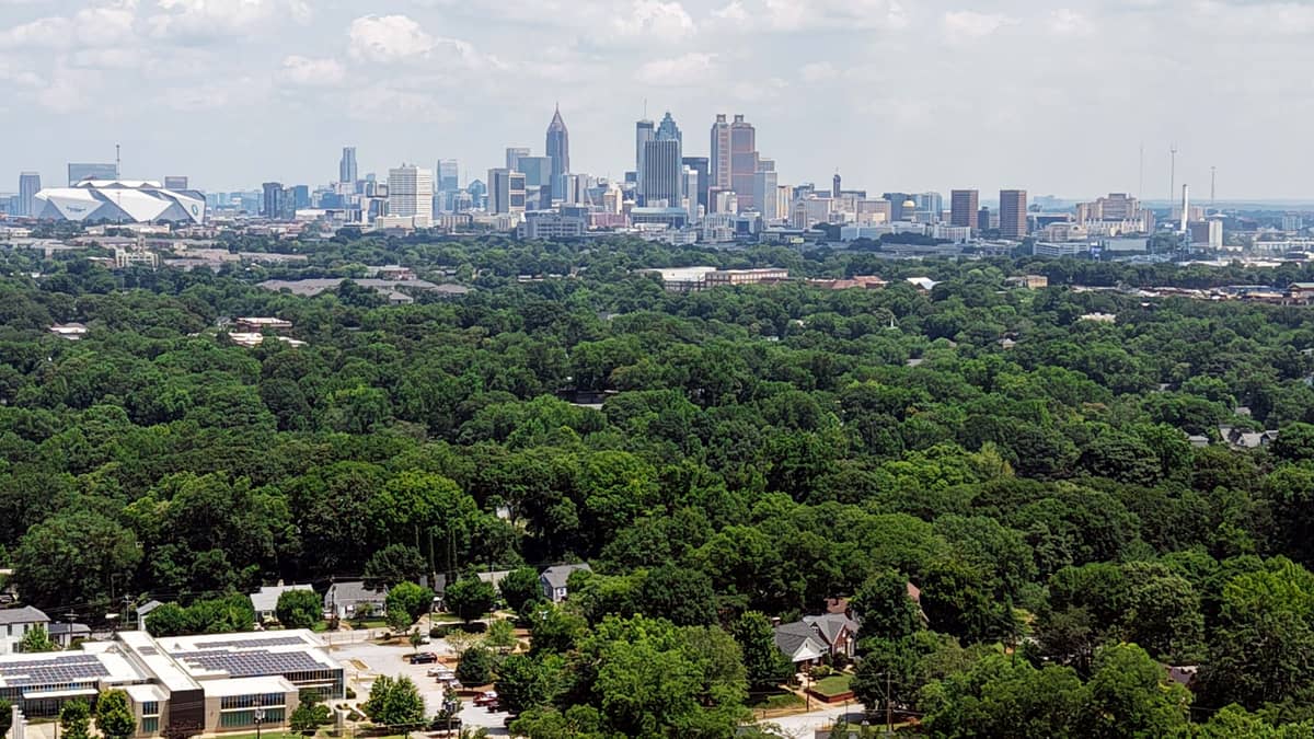 The downtown Atlanta, Georgia skyline rising above the city tree canopy, with Mercedes-Benz Stadium